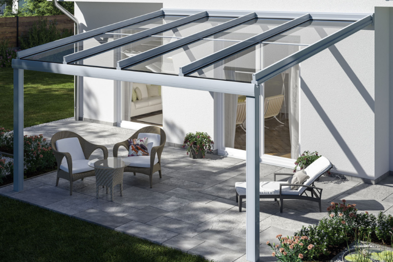 Weiße Terrassenüberdachung Murano Puro mit Glasdach und Gartenmöbeln